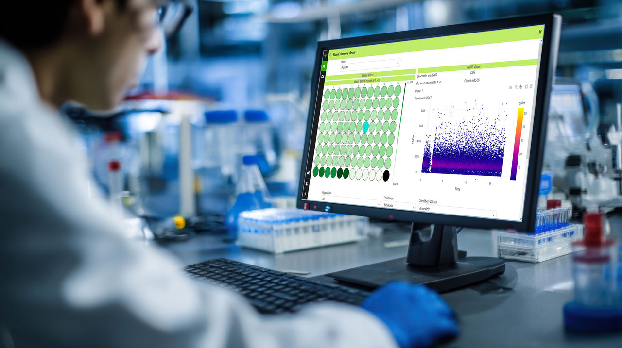 In a well-equipped laboratory, a scientist is focused on a computer screen displaying a vibrant data visualization. Colorful patterns indicate complex data analysis, showcasing research progress