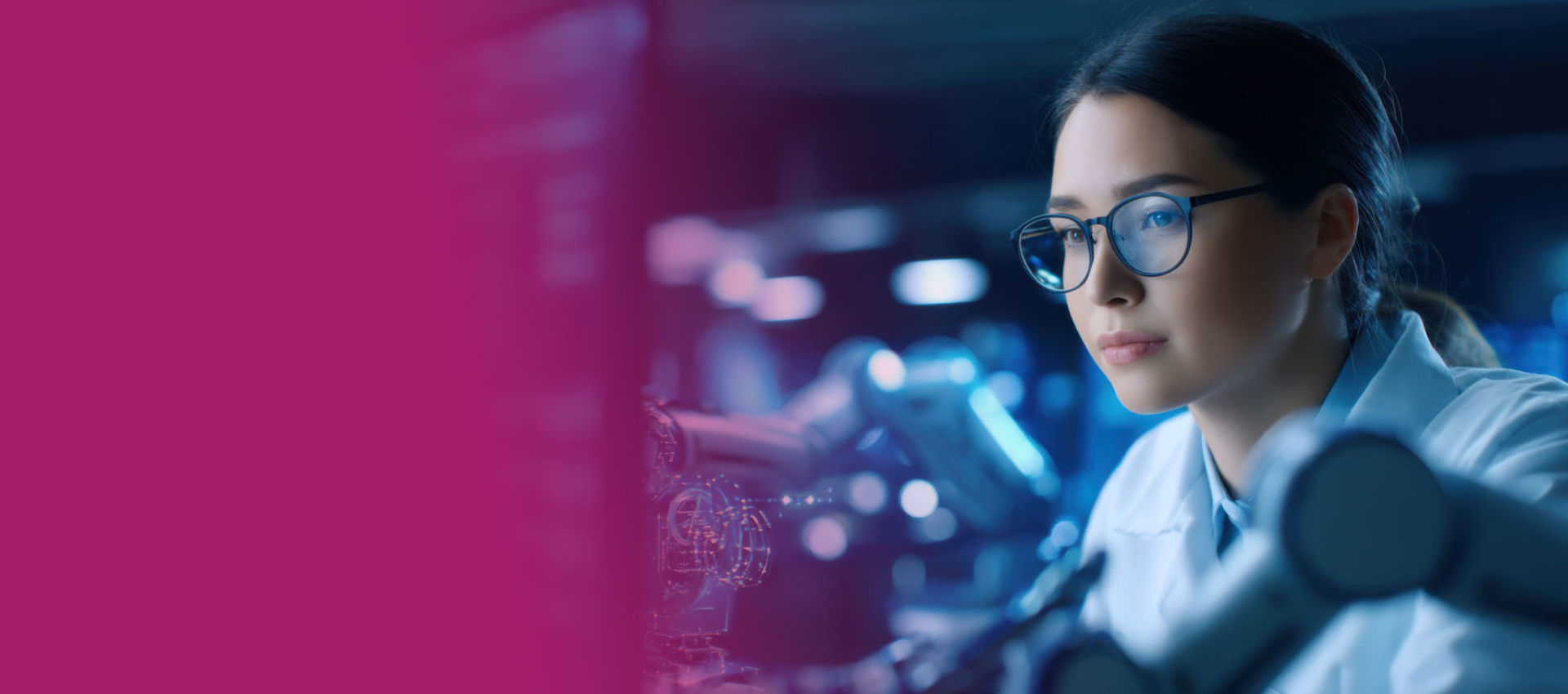 A female scientitst sitting in a lab looking at a monitor.